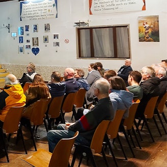 In mehreren Stuhlreihen sitzen interessierte Bürger, vorne stellt ein e-regio-Vertreter die Pläne vor.