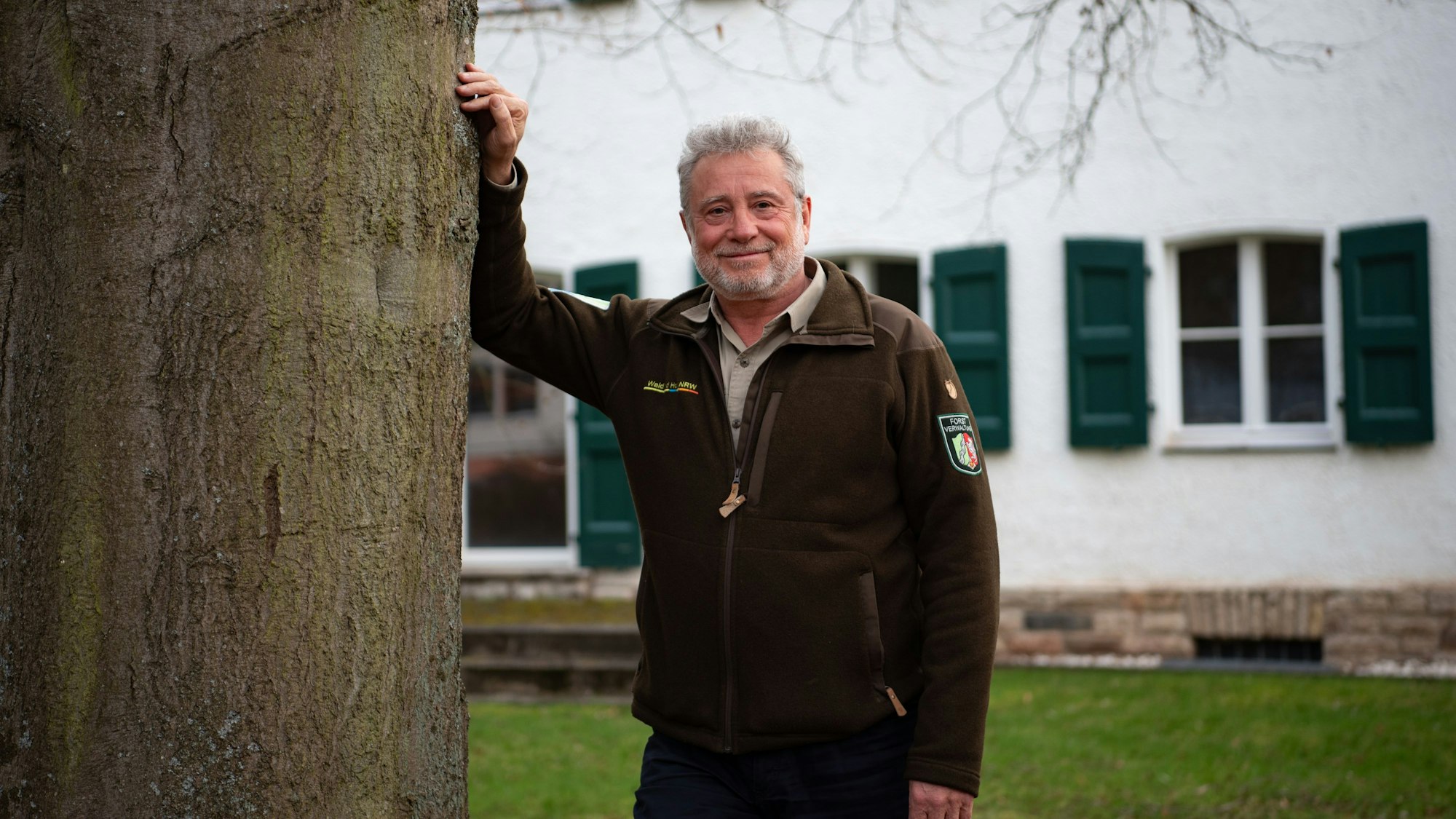 Michael Lammertz lehnt an eine heimische Buche vor der Nationalparkverwaltung in Gemünd.