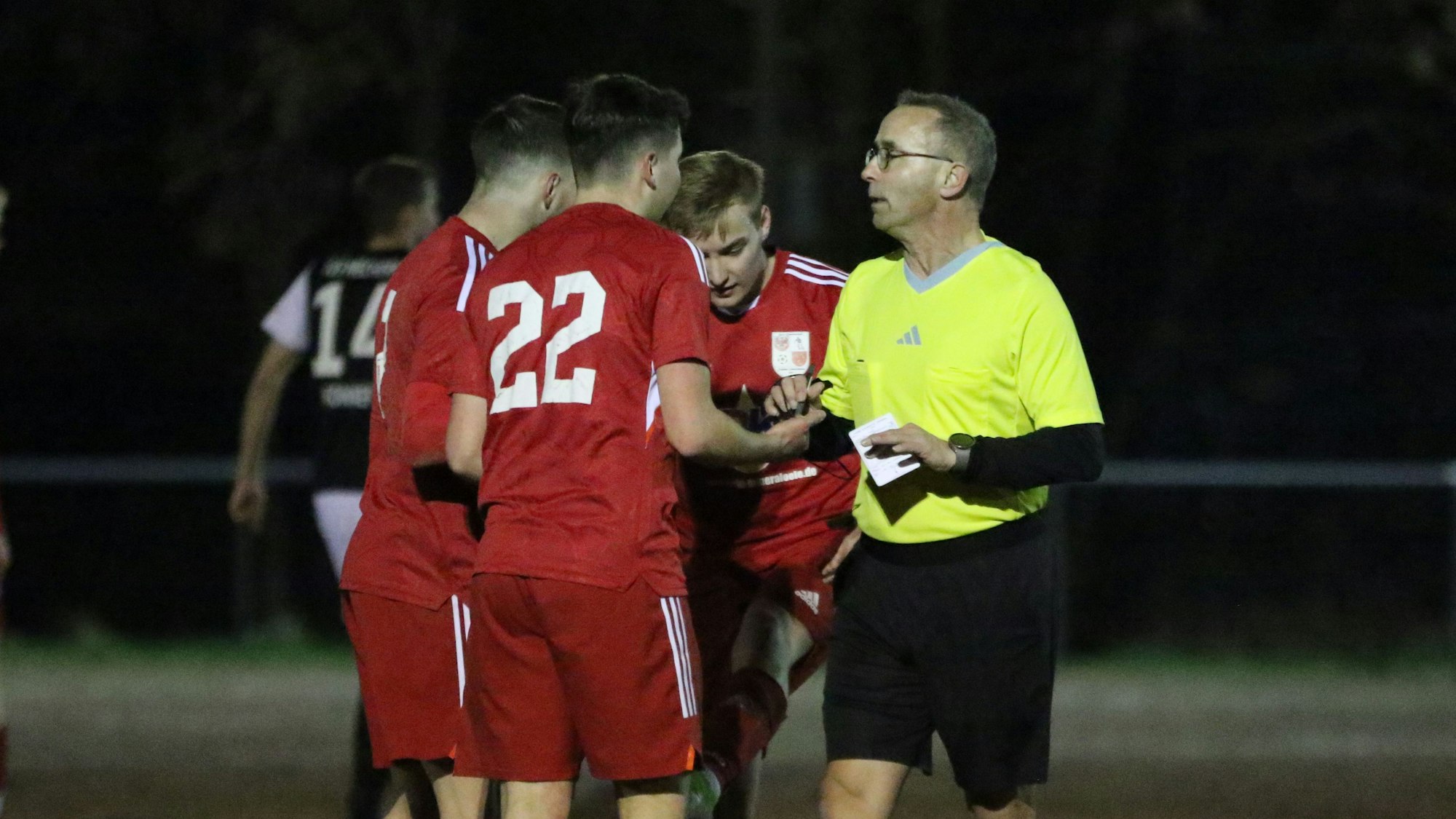 Schiedsrichter Maik Claus im Gespräch mit Dahlemer Spielern.