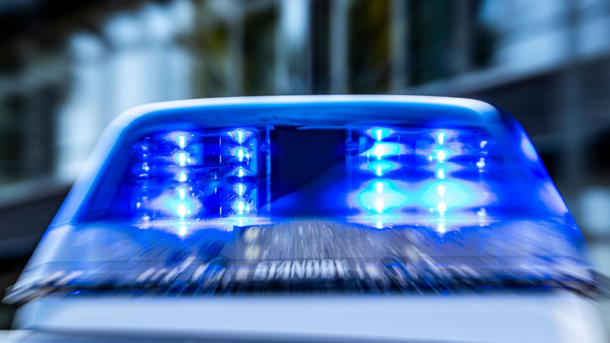 Das Blaulicht an einem Polizeiwagen ist eingeschaltet.