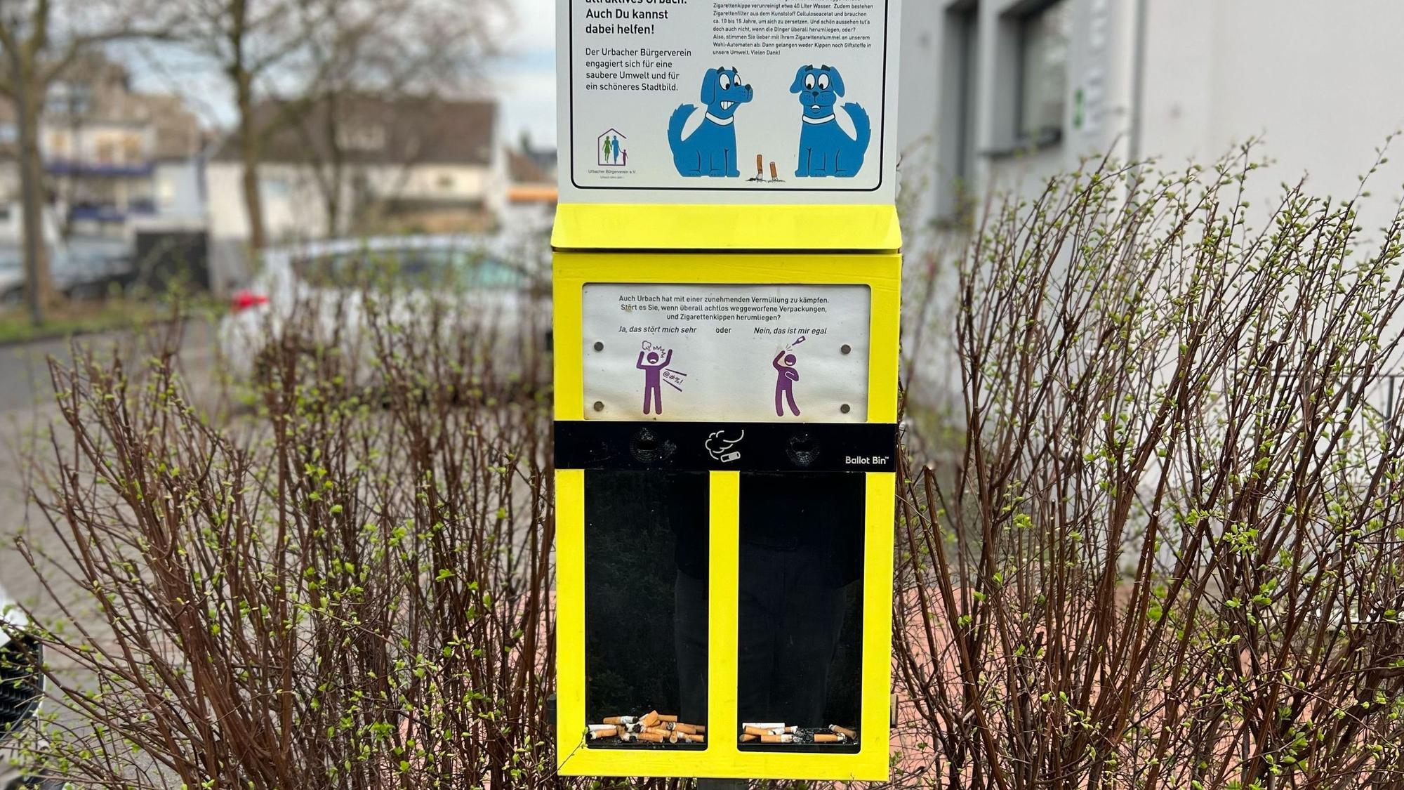 Ein gelber Sammelbehälter für Zigarettenkippen mit zwei Fächern.