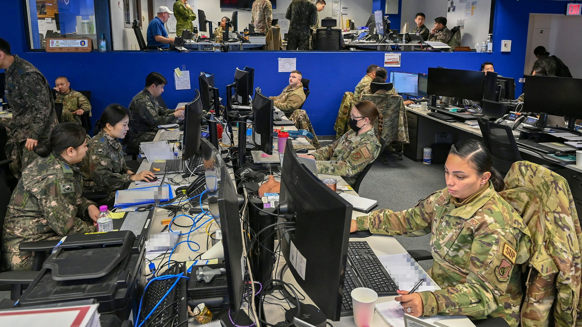 04.03.2024, Südkorea, Pyeongtaek: Südkoreanische und US-Soldaten des Combined Air Component Command sitzen im Korean Air and Space Operations Center auf dem Luftwaffenstützpunkt Osan, am ersten Tag der 11-tägigen jährlichen gemeinsamen Militärübung «Freedom Shield 2024»
