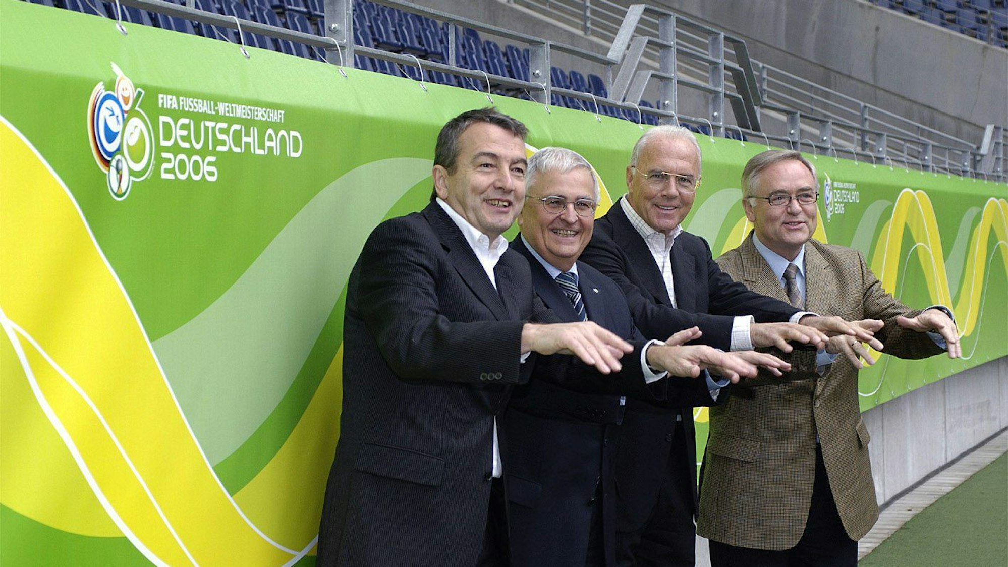 Das Präsidium des Organisationskomitees für die Fußball-Weltmeisterschaft 2006 in Deutschland (l-r): Vizepräsident Wolfgang Niersbach, Vizepräsident Theo Zwanziger, Präsident Franz Beckenbauer und der 1. Vizepräsident Horst R. Schmidt stehen im Frankfurter Waldstadion vor einer Bandenwerbung für die Fußball Weltmeisterschaft 2006.