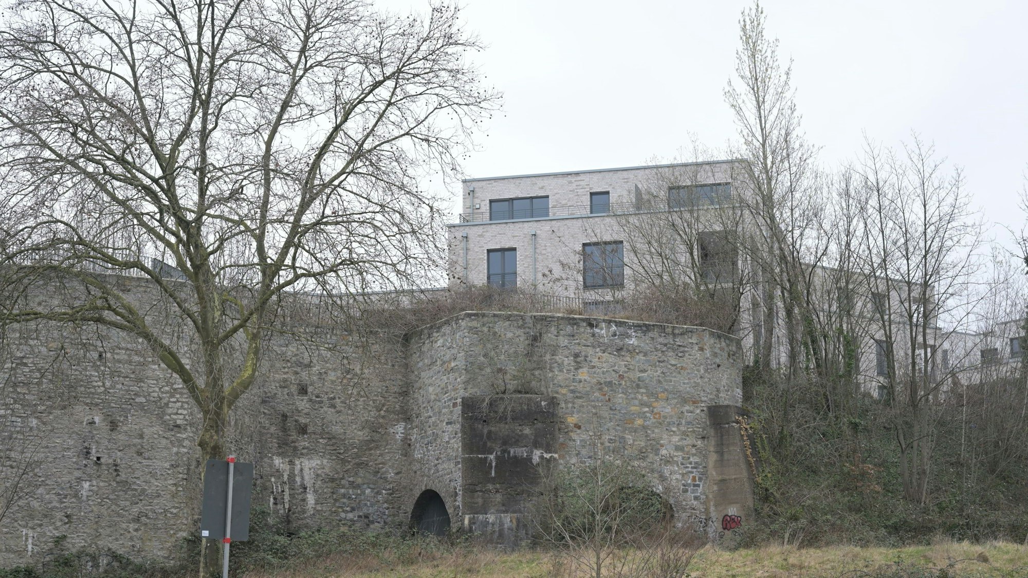 Im Vordergrund sieht man die Mauern der alten Kalköfen. Darüber hinaus ragen zwei Stockwerke der Neubauten.