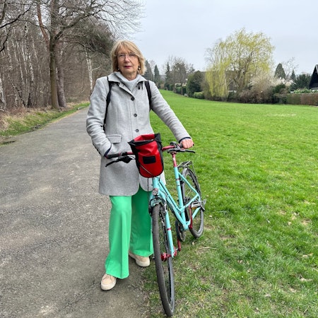 Ratsmitglied Gabriele Gassen von den Grünen an der Wiese in Sankt Augustin, wo der Bürgerwald entstehen soll.