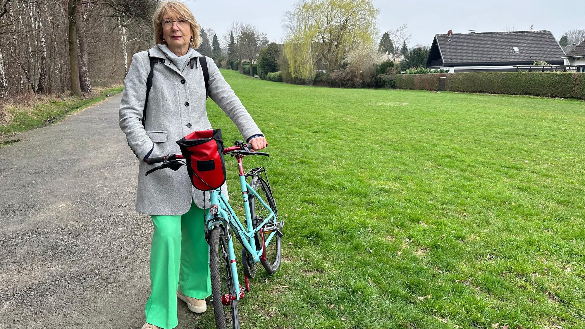 Ratsmitglied Gabriele Gassen von den Grünen an der Wiese in Sankt Augustin, wo der Bürgerwald entstehen soll.