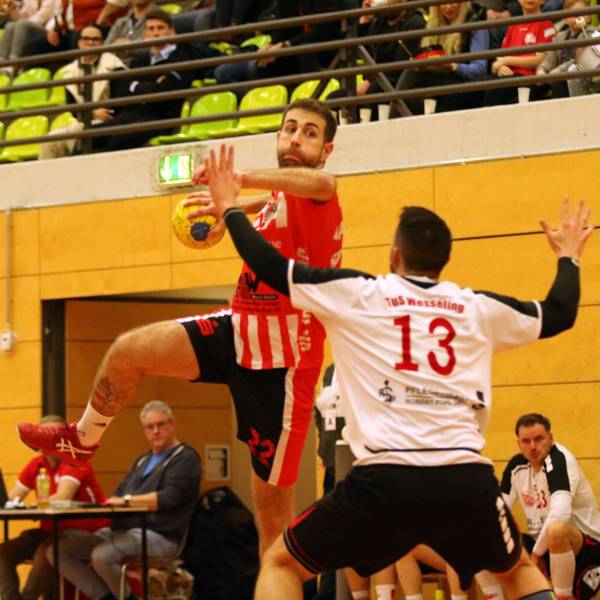 Das Bild zeigt David Henzel beim Sprungwurf. Ein Abwehrspieler versucht zu blocken.