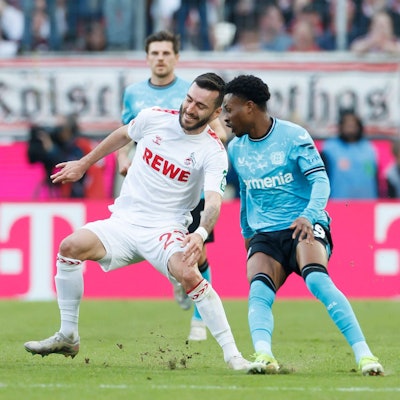 Nicht alles im grünen Bereich: Beim Zweikampf zwischen Kölns Sargis Adamyan und Leverkusens Nathan Tella fliegen die Rasenstücke.