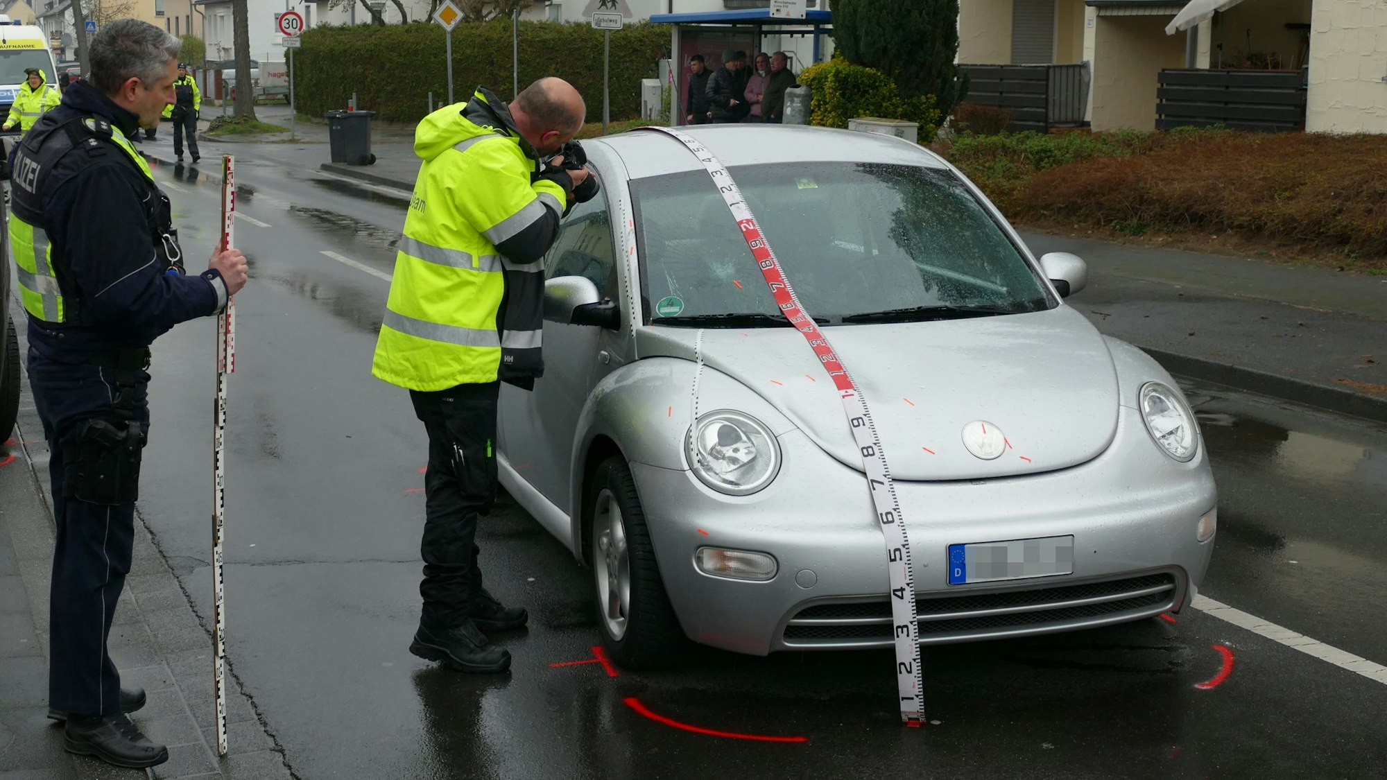 Polizeibeamte sichern Spuren an dem Auto.