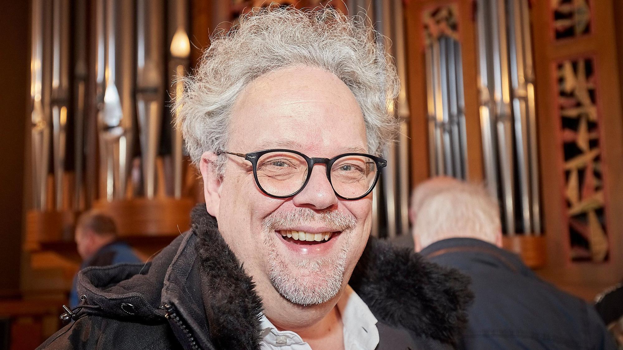 Erik Arndt ist Leiter von insgesamt fünf Chören. Er steht vor der Orgel in der Mechernicher Pfarrkirche.