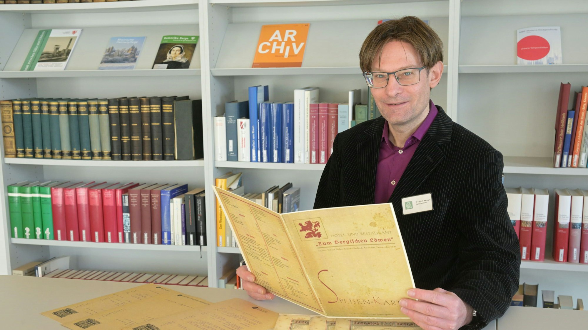 Auch früher wusste man fein zu speisen: Archivar Michael Krischak-Wareeyan mit einer historischen Speisekarte.