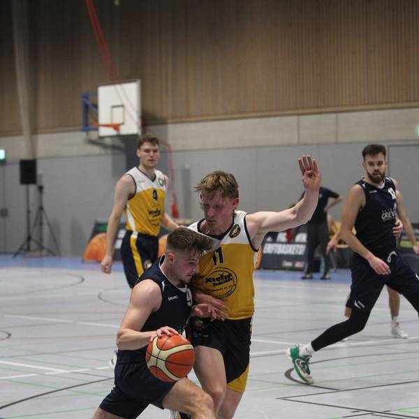 Jan Züll hält mit dem linken Arm einen Gegner von sich fern, mit dem rechten führt er den Ball.