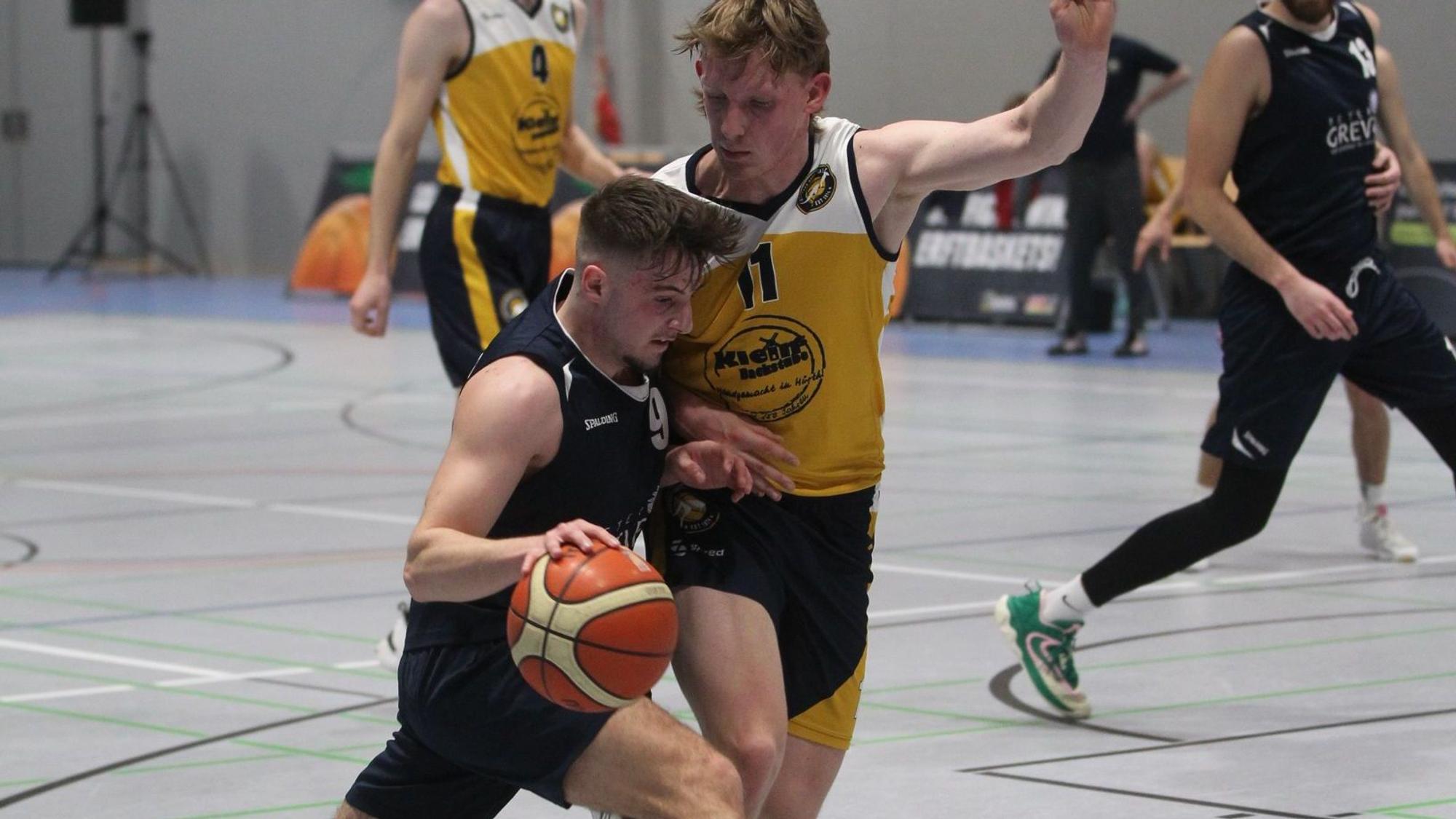 Jan Züll hält mit dem linken Arm einen Gegner von sich fern, mit dem rechten führt er den Ball.