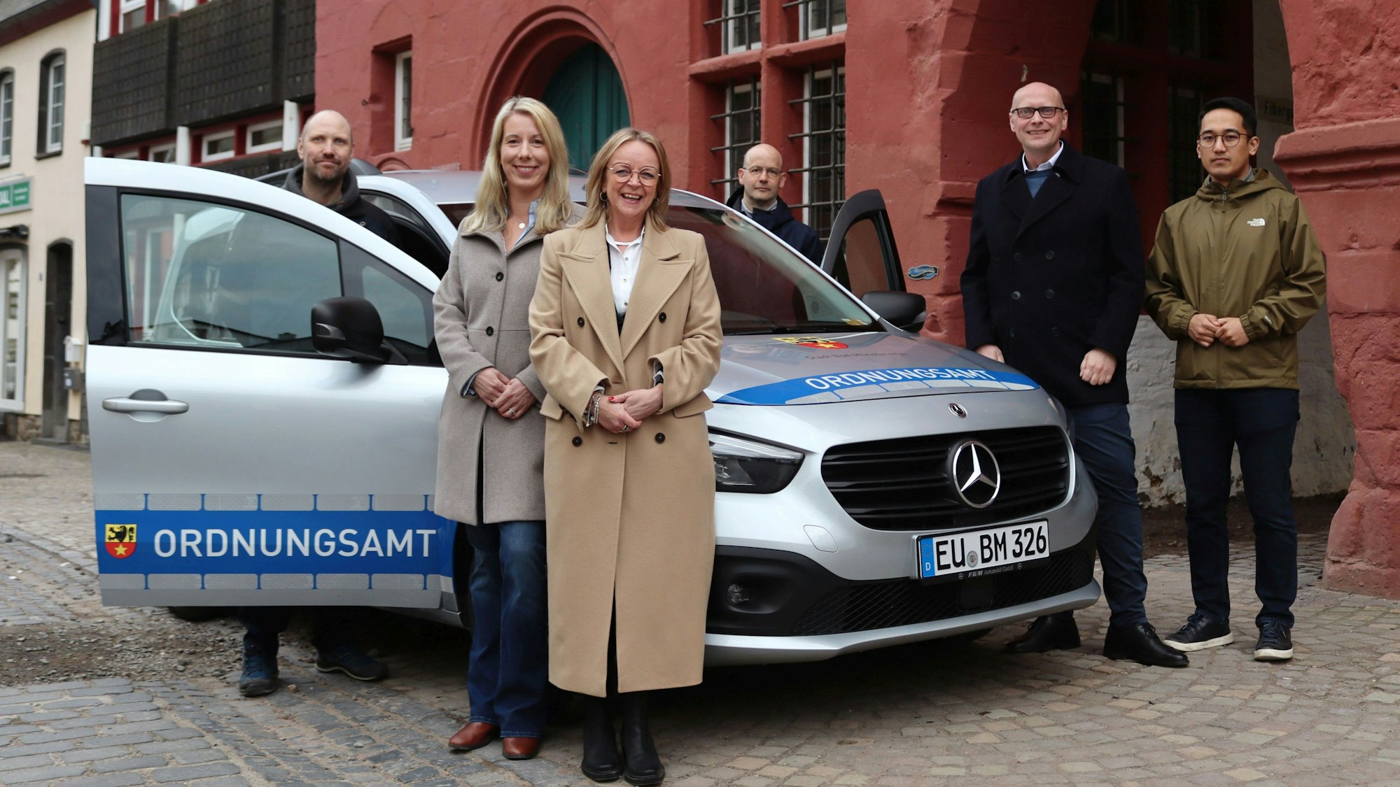 Sechs Personen stehen um den silbernen Mercedes-Benz Citan Tourer vor dem Rathaus von bad Münstereifel. Es handelt sich um Andreas Lanzerath (Außendienst Ordnungsamt), Gina Burgwinkel-Ernst (Leiterin des Amtes für Öffentliche Sicherheit, Soziales und Ordnung), Bürgermeisterin Sabine Preiser-Marian, Thomas Lippertz (Außendienst Ordnungsamt), Sebastian Glatzel (Vorsitzender SPD-Fraktion) und Tenzin Naktsang (stellv. Vorsitzender SPD-Fraktion).