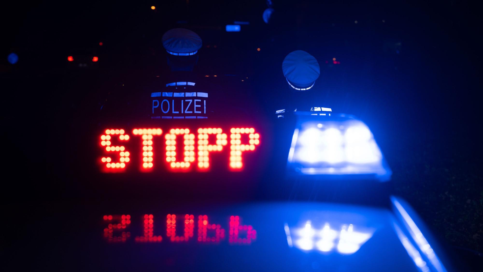 as Wort „Stopp“ ist auf dem Dach eines Polizeiwagens zu lesen.