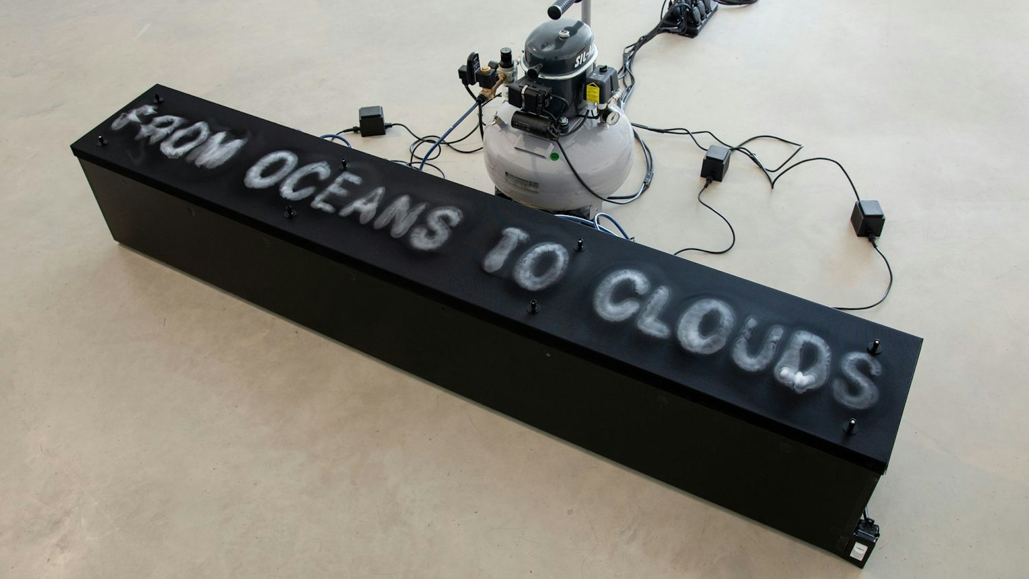 Auf einem schwarzen Block steht in weiß „FROM OCEANS TO CLOUDS“.