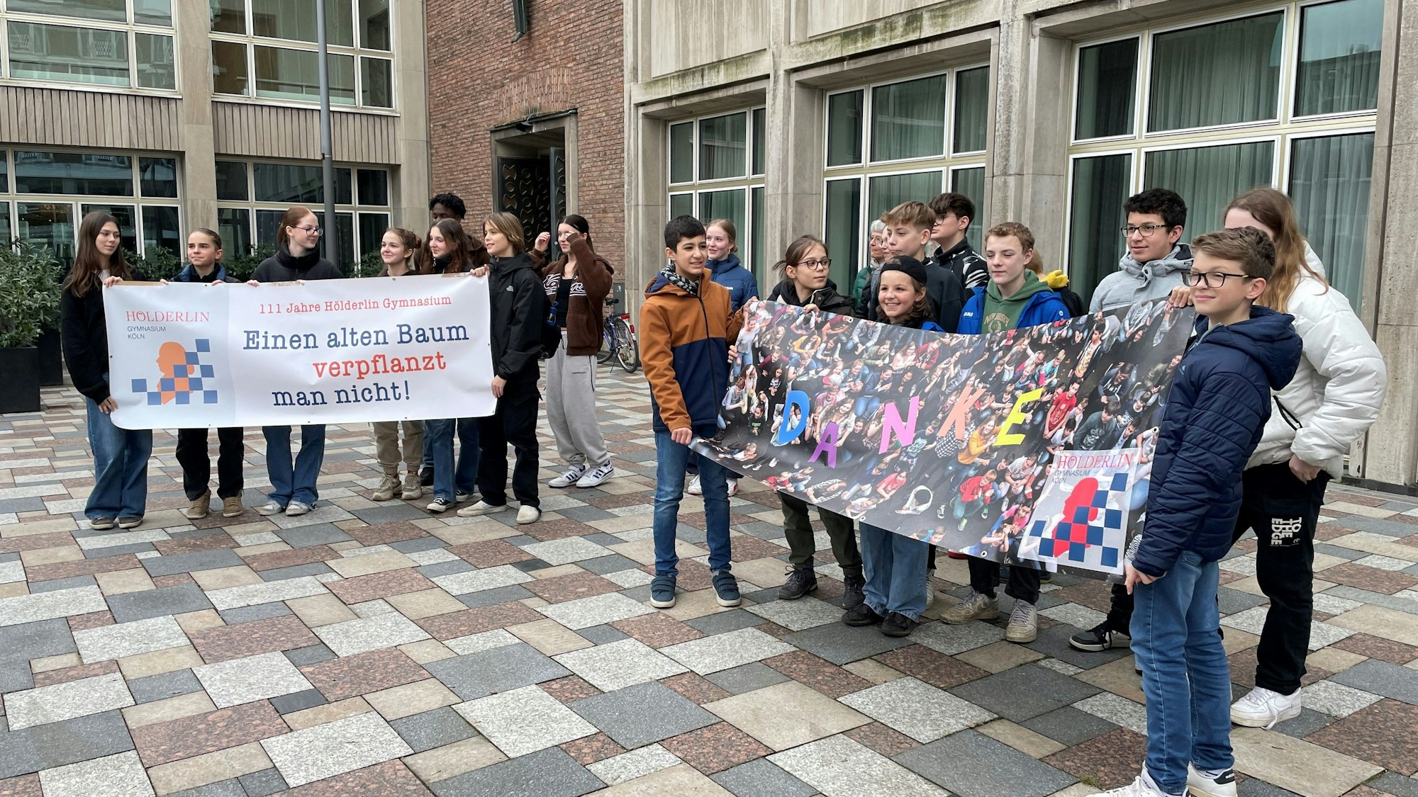 Schüler des Hölderlin-Gymnasiums bedanken sich mit Plakaten auf dem Rathausplatz nach dem Beschluss des Schulausschusses für den Neubau ihrer Schule.