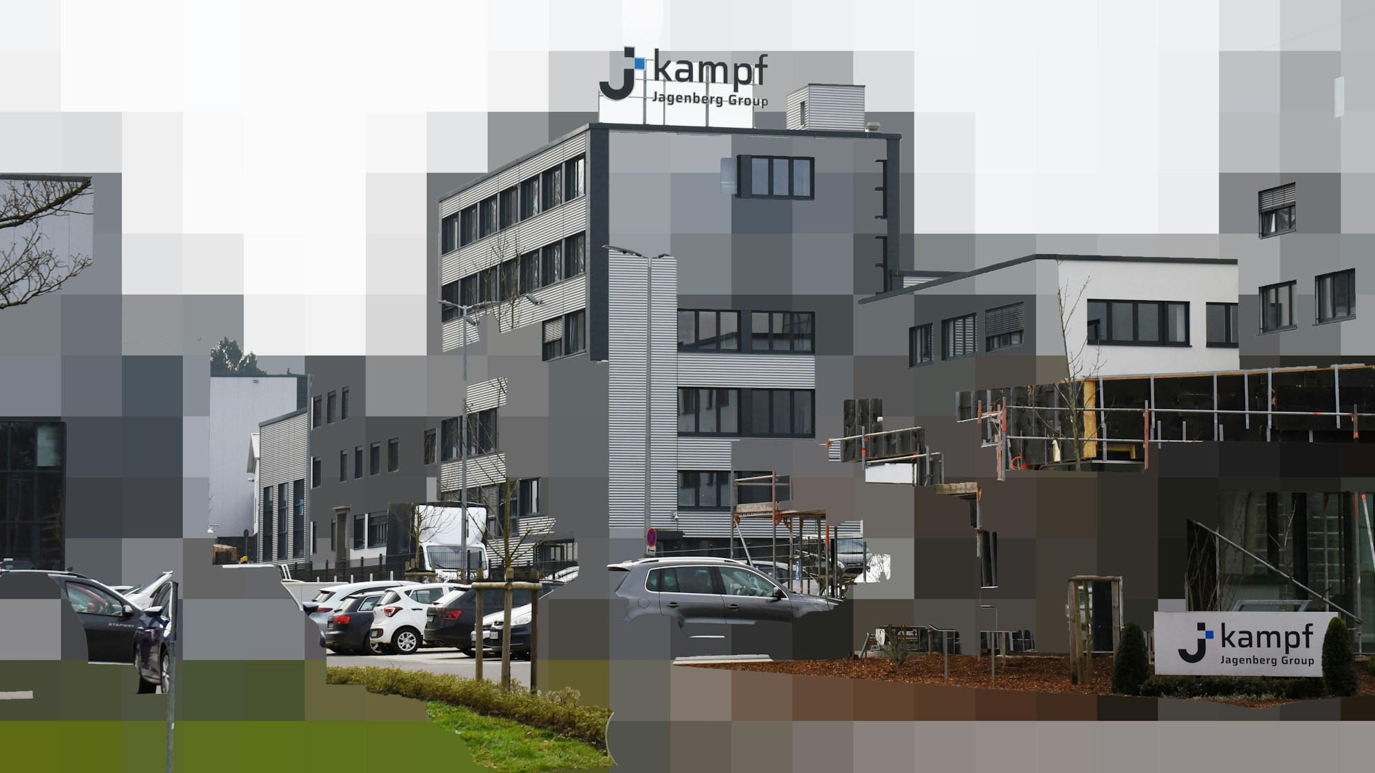 Eine Außenaufnahme des Firmengebäudes, teilweise grob verpixelt.