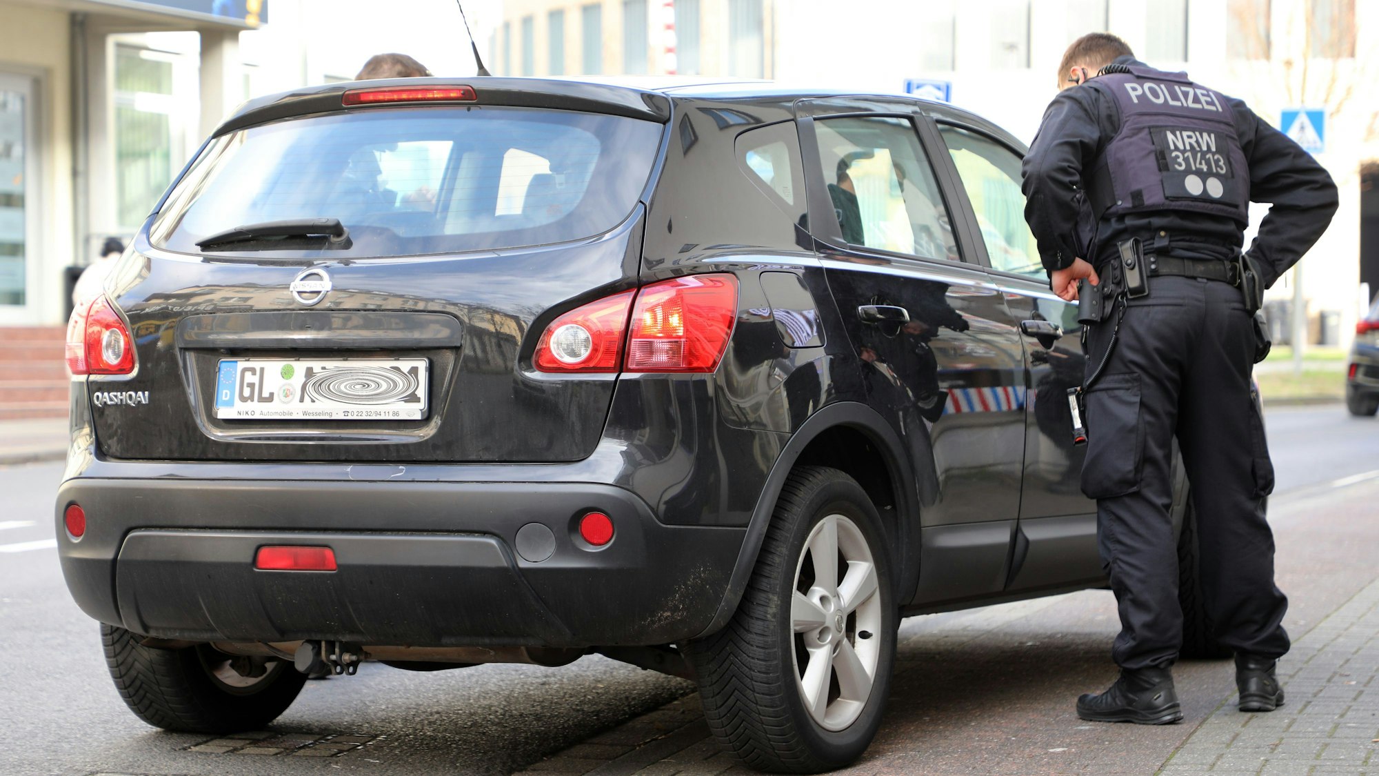 Polizeibeamte einer Einsatzhundertschaft bei einer Verkehrskontrolle auf der Hauptstraße in Bergisch Gladbach.