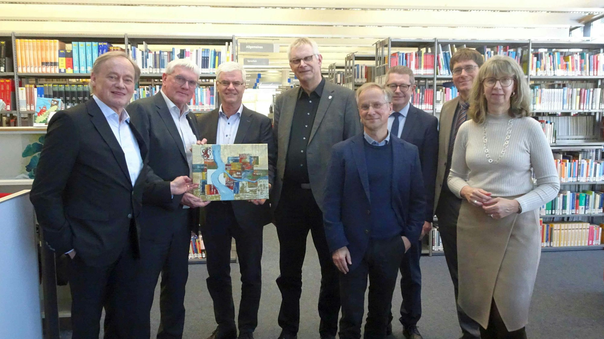 Landrat Sebastian Schuster (2.v.l.) übergab ein Geschenk an Bibliotheksleiter Dr. Armin Ehrhardt (rechts daneben) im Beisein von Kanzlerin Angela Fischer (rechts) Präsident Hartmut Ihne (l.), Bürgermeister Ludger Banken (4.v.l.), Hans Dieter Wirtz (3.v.r.) und die Dekane Richard Jäger (4.v.r.) und Peter Muck (2.v.r.).