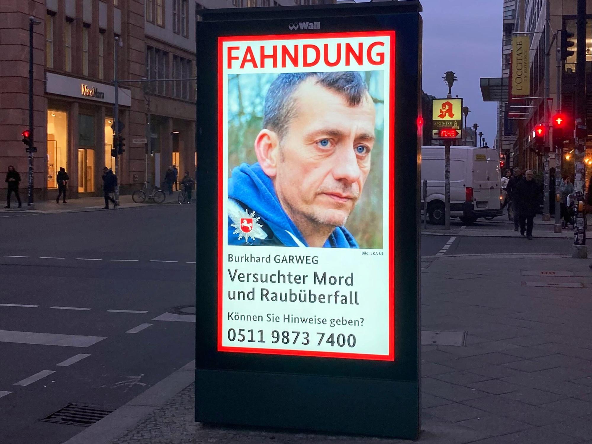 Ein Fahndungsplakat des LKA Niedersachsen zeigt den mutmaßlichen früheren RAF-Terroristen Burkhard Garweg auf einer digitalen Anzeigetafel in Berlin.