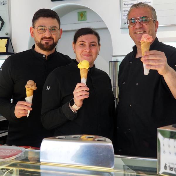 Zwei Männer und eine Frau halten Eishörnchen mit verschiedenfarbigen Eiskugeln in die Höhe.