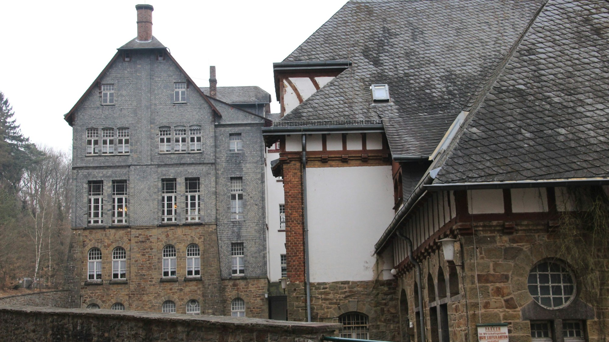 Ein großes, verschachteltes Gebäude aus Bruchstein, Fachwerk und Schiefer.