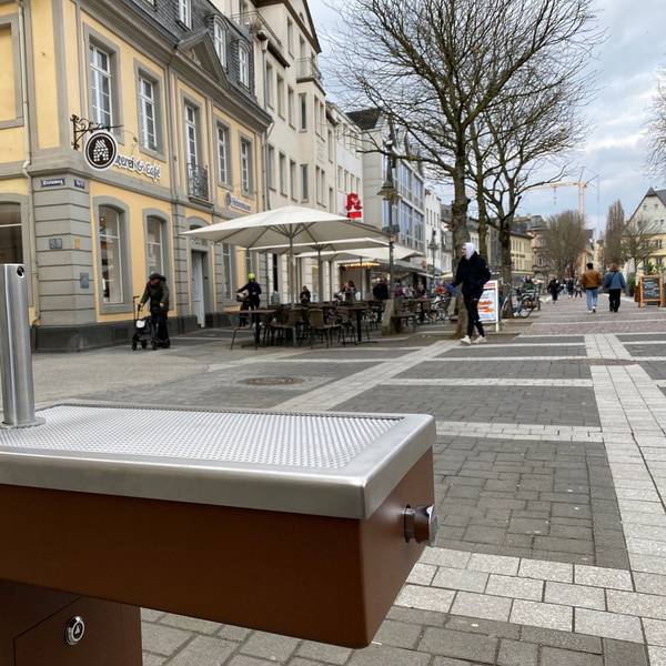 Zu sehen ist einer der Trinkwasserbrunnen, im Hintergrund sieht man die Brühler Fußgängerzone.