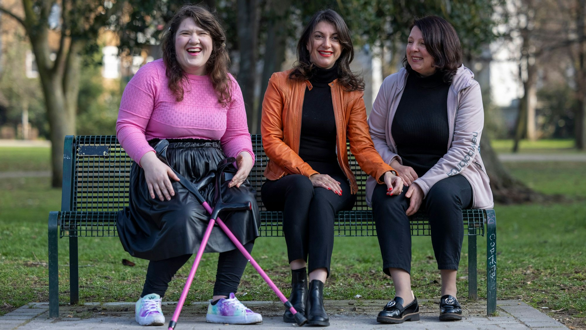 Drei Frauen sitzen auf einer Barkbank.