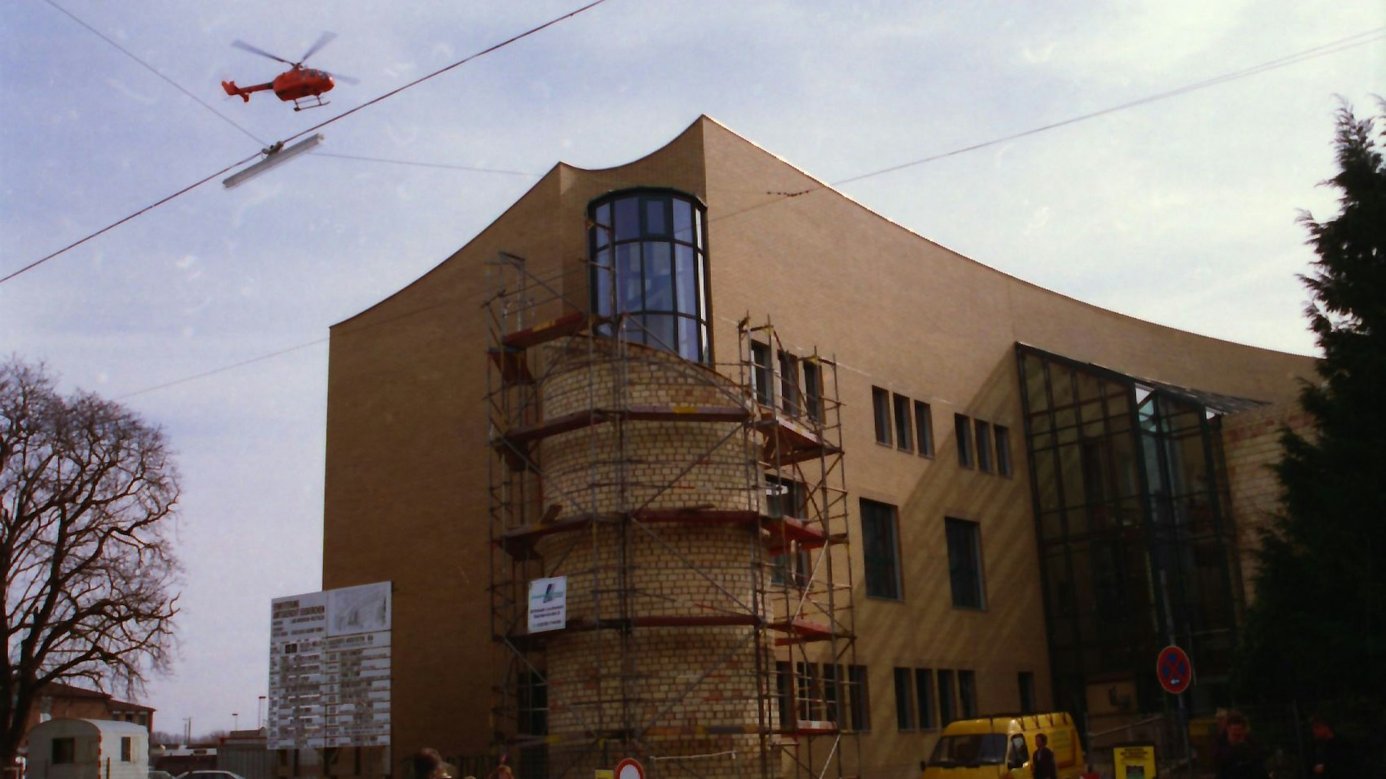 Das Bild zeigt die Baumaßnahmen am neuen Amtsgericht. In der Luft fliegt ein Rettungshubschrauber.