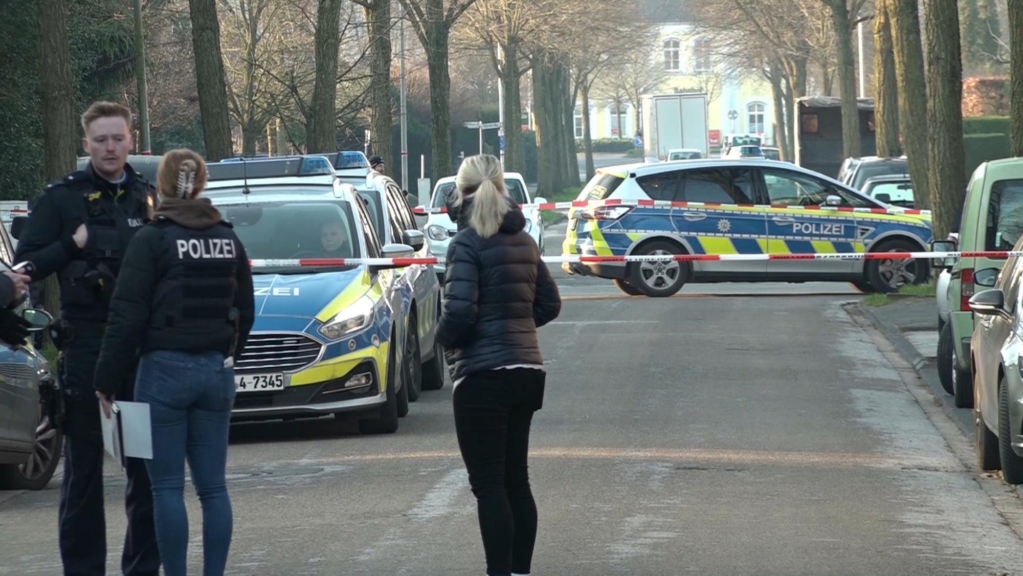 Ochtrup: Einsatzkräfte der Polizei stehen vor Absperrband auf einer Straße.