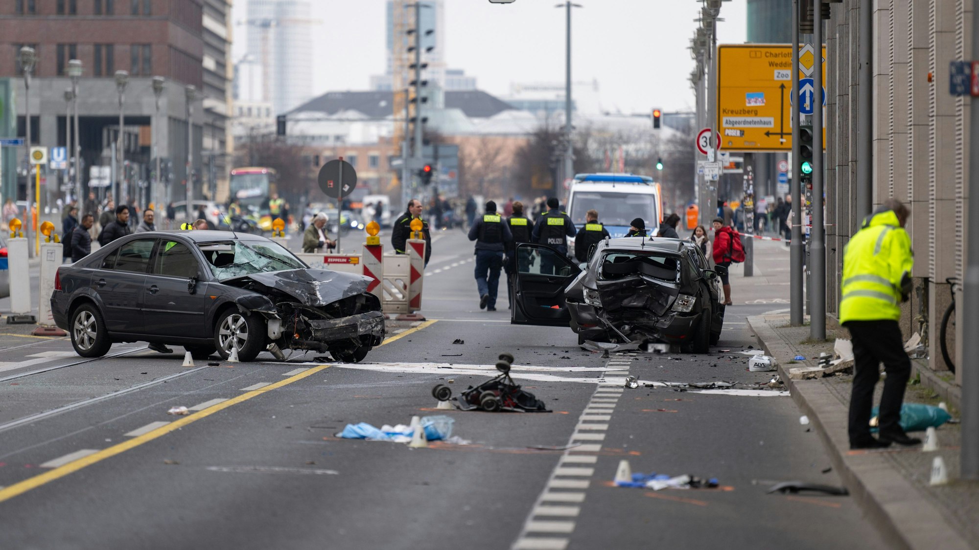 Polizisten stehen an einer Unfallstelle in der Leipziger Straße in Berlin. Bei dem schweren Unfall in Berlin-Mitte sind vier Ein Kennzeichen wurde aus rechtlichen Gründen gepixelt +++ dpa-Bildfunk +++