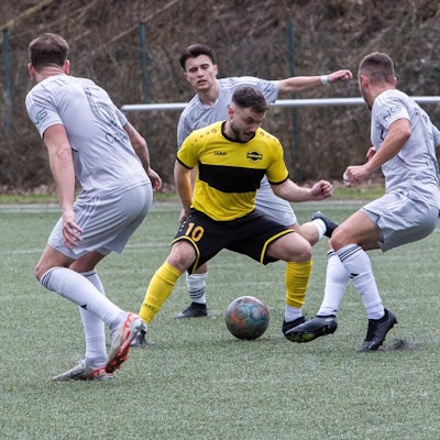 Ein Hohkeppeler Spieler wird mit dem Ball am Fuß von drei Spielern von Germania Teveren umringt.