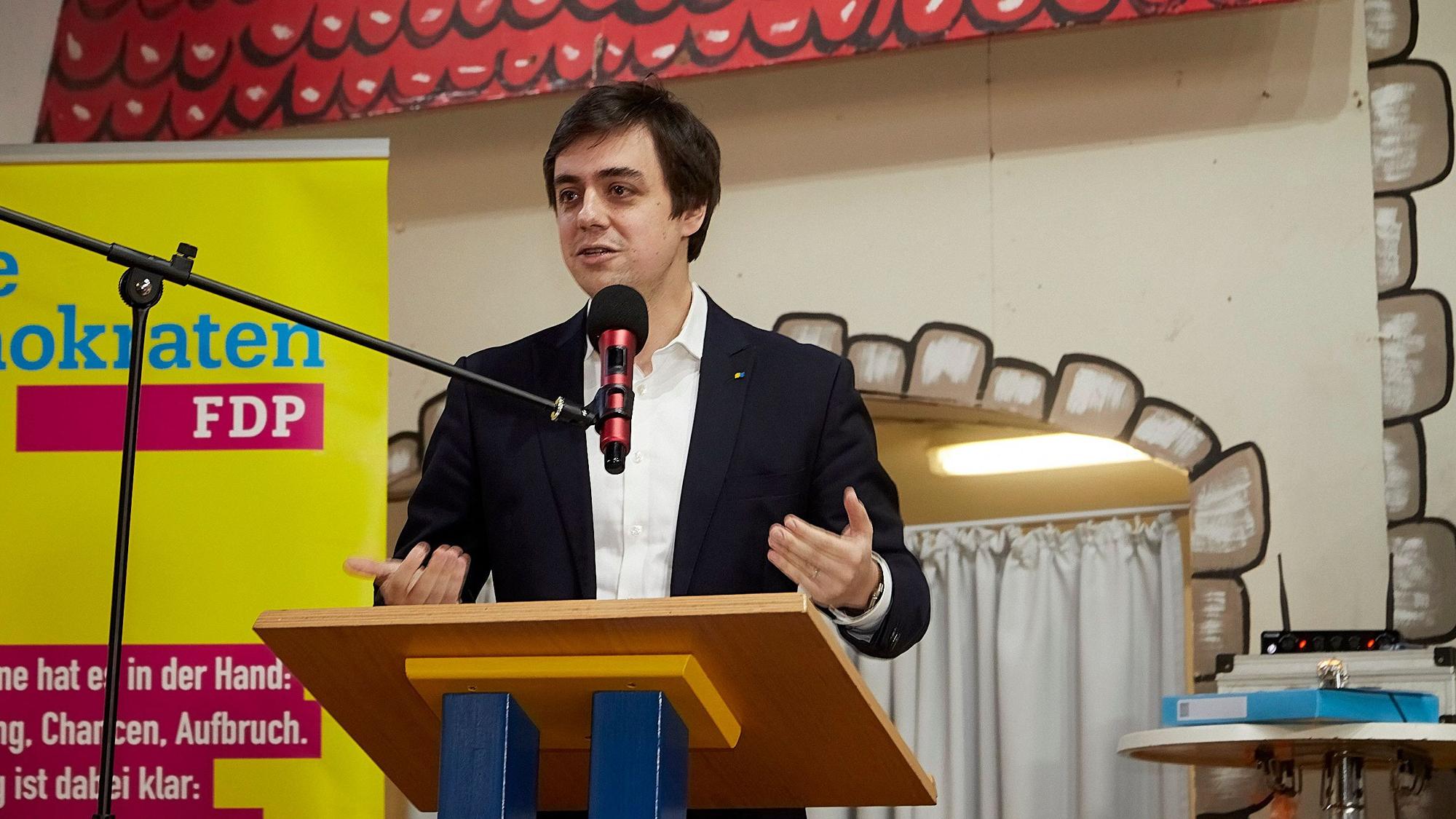 Der FDP-Kreisvorsitzende Frederik Schorn steht an einem Rednerpult und spricht in ein Mikrofon.