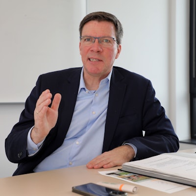 Landrat Stephan Santelmann sitzt an einem Tisch im Kreishaus am Rübezahlwald in Bergisch Gladbach und spricht.