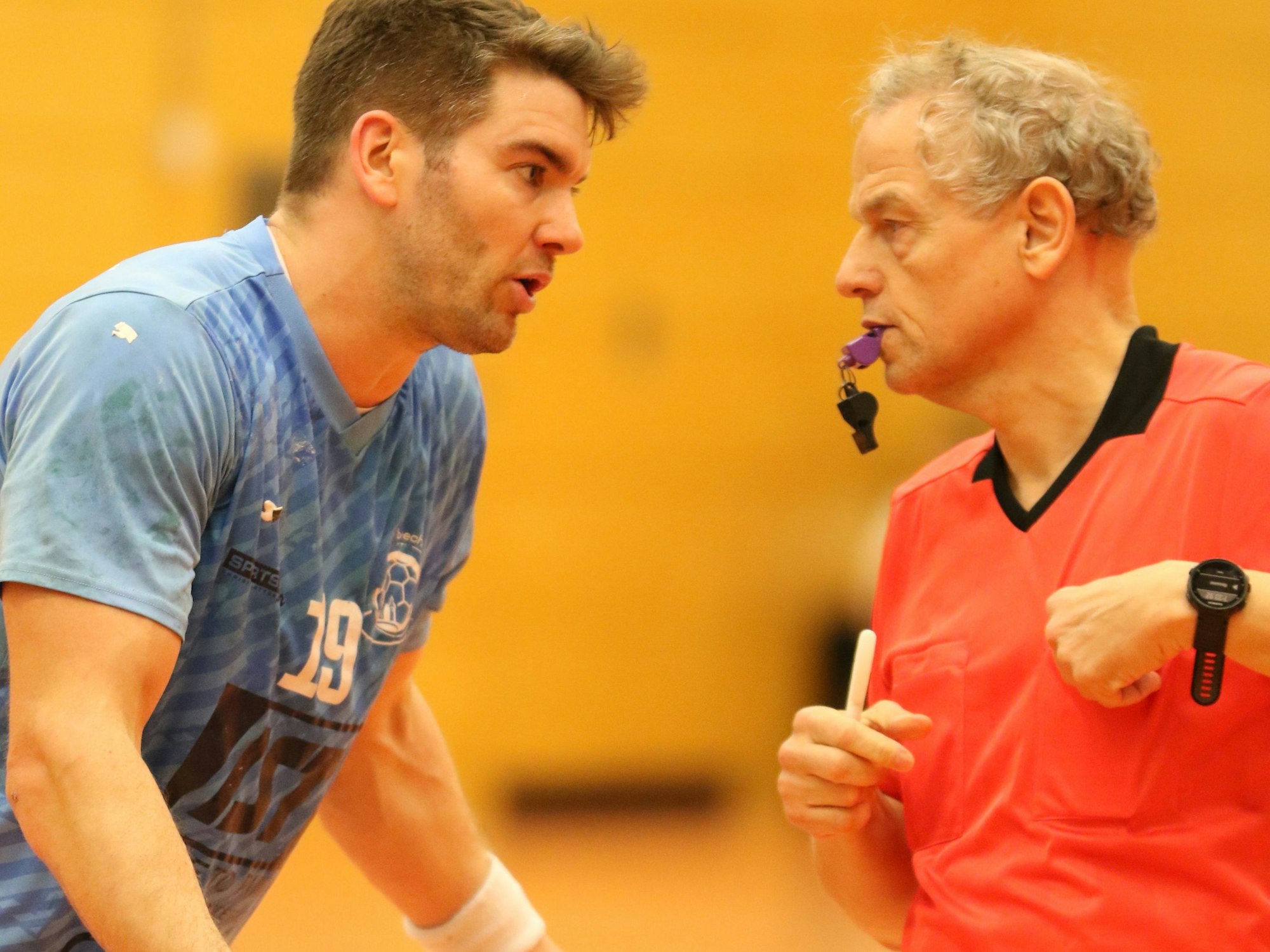 Nümbrechts Tim Hartmann diskutiert mit ausgebreiteten Armen mit dem Schiedsrichter, der an seine Brusttasche greift.