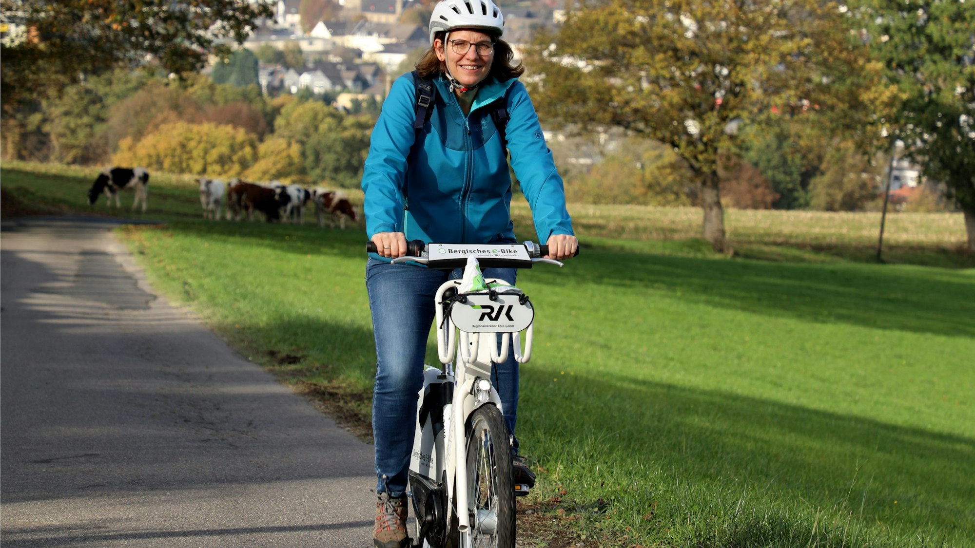 Eine E-Bike-Fahrerin auf einer Landstraße.