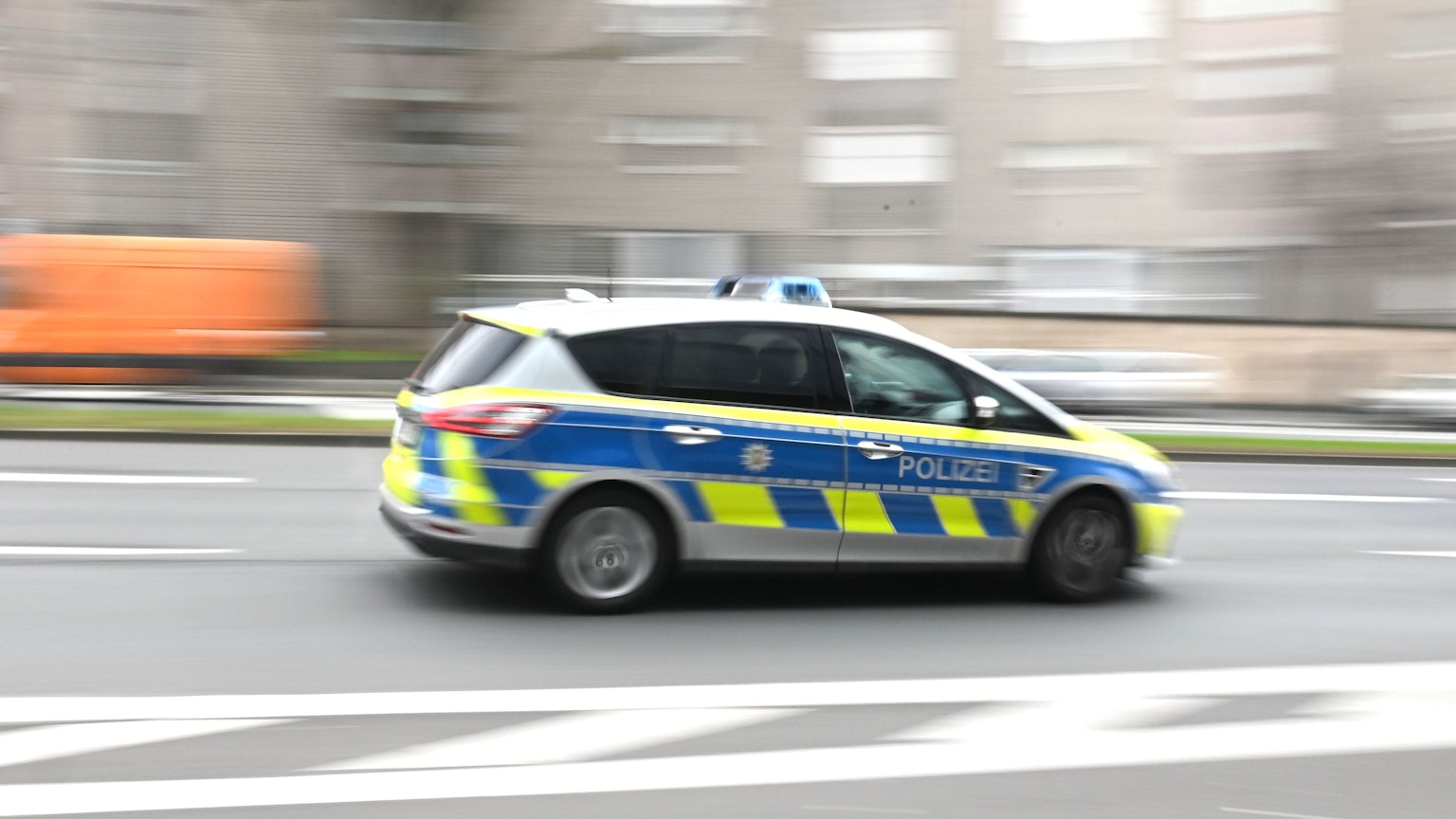 Symbolbild. Ein Polizeiwagen eilt durch die Stadt.