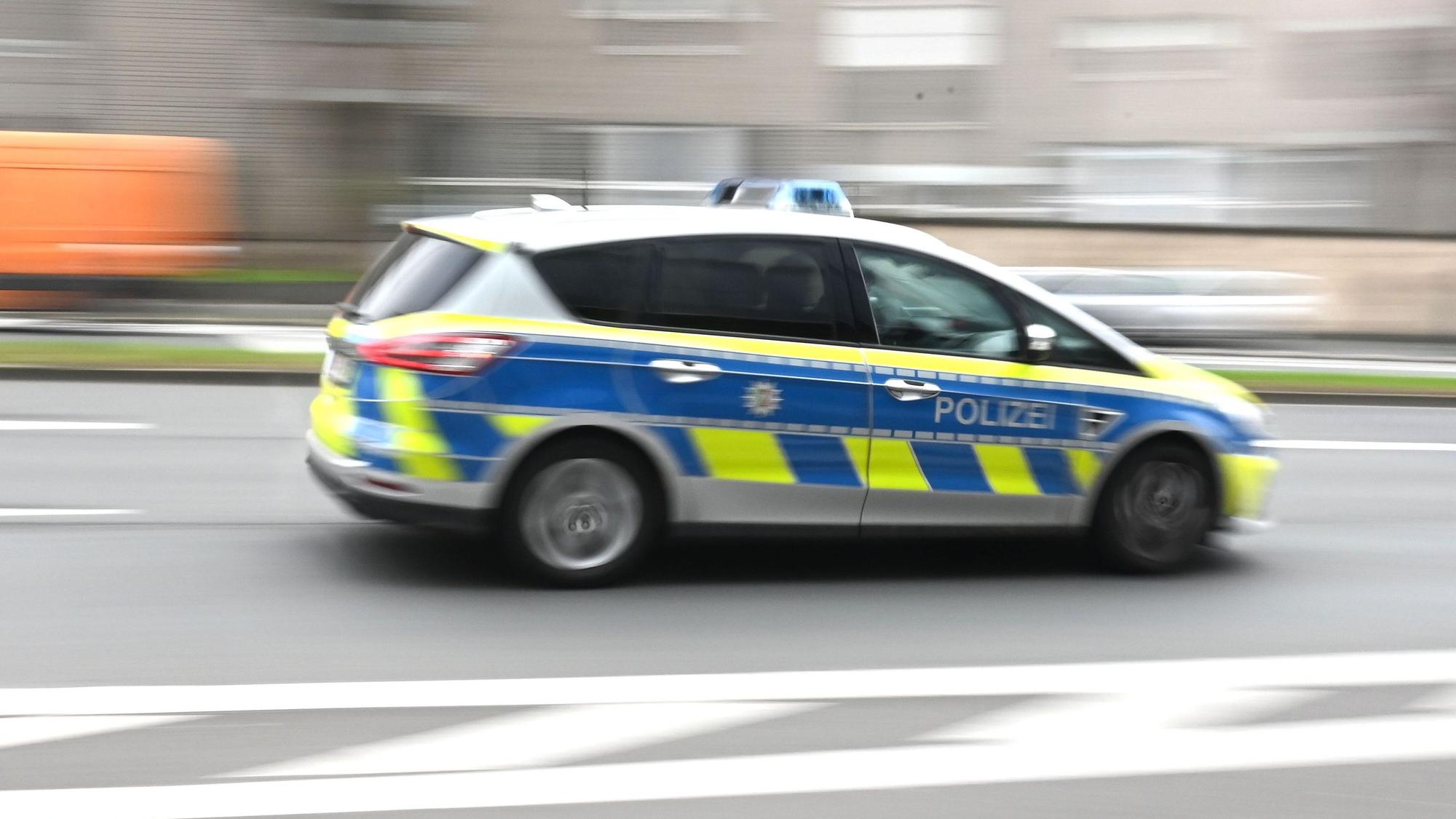 Symbolbild. Ein Polizeiwagen eilt durch die Stadt.