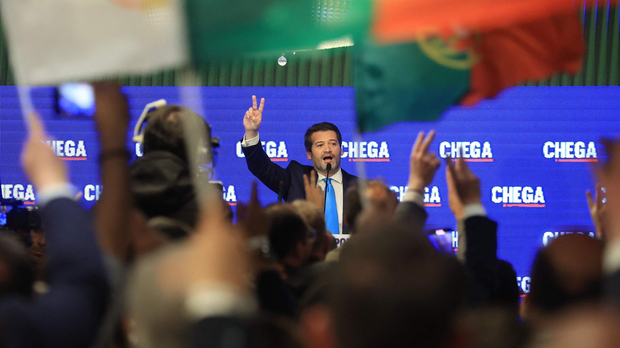 André Ventura, Chega-Vorsitzender, formt zwei Finger zu einem Siegeszeichen auf der Bühne vor Anhängern seiner Partei.