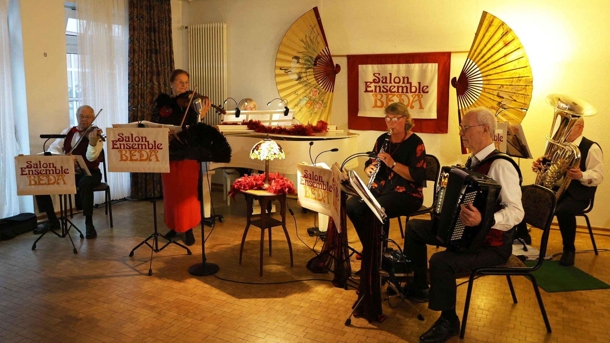 Die Mitglieder des Ensembles spielen im stimmungsvoll beleuchten Gemeindesaal.