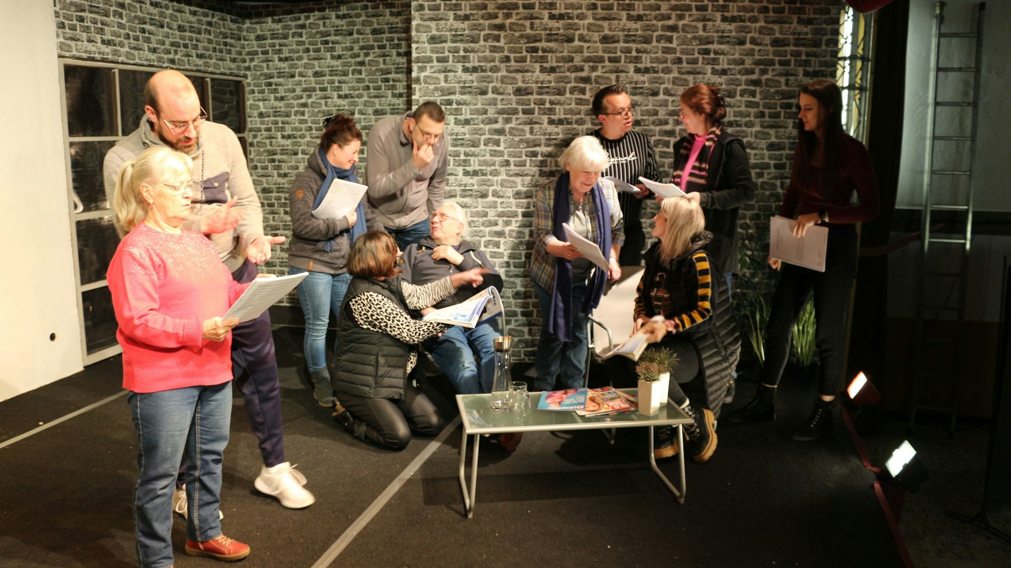 Das Bild zeigt die Schauspieler bei den Proben noch mit Textblättern.