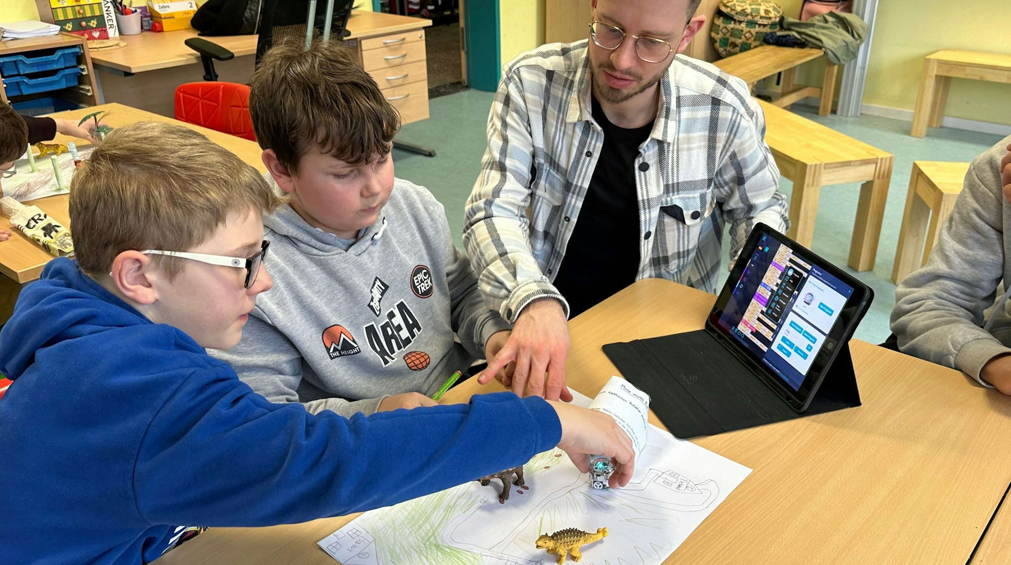 Lehrer Philipp Krawietz hilft beim Programmieren der Wegstrecke.
