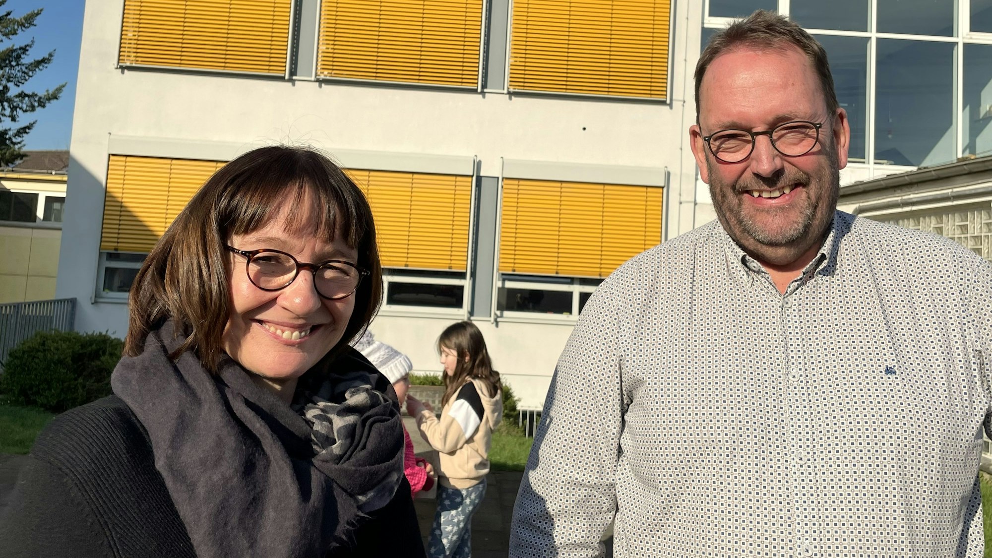 Ein Mann steht vor einem großen Schild, auf dem Schule IM Süden steht.
