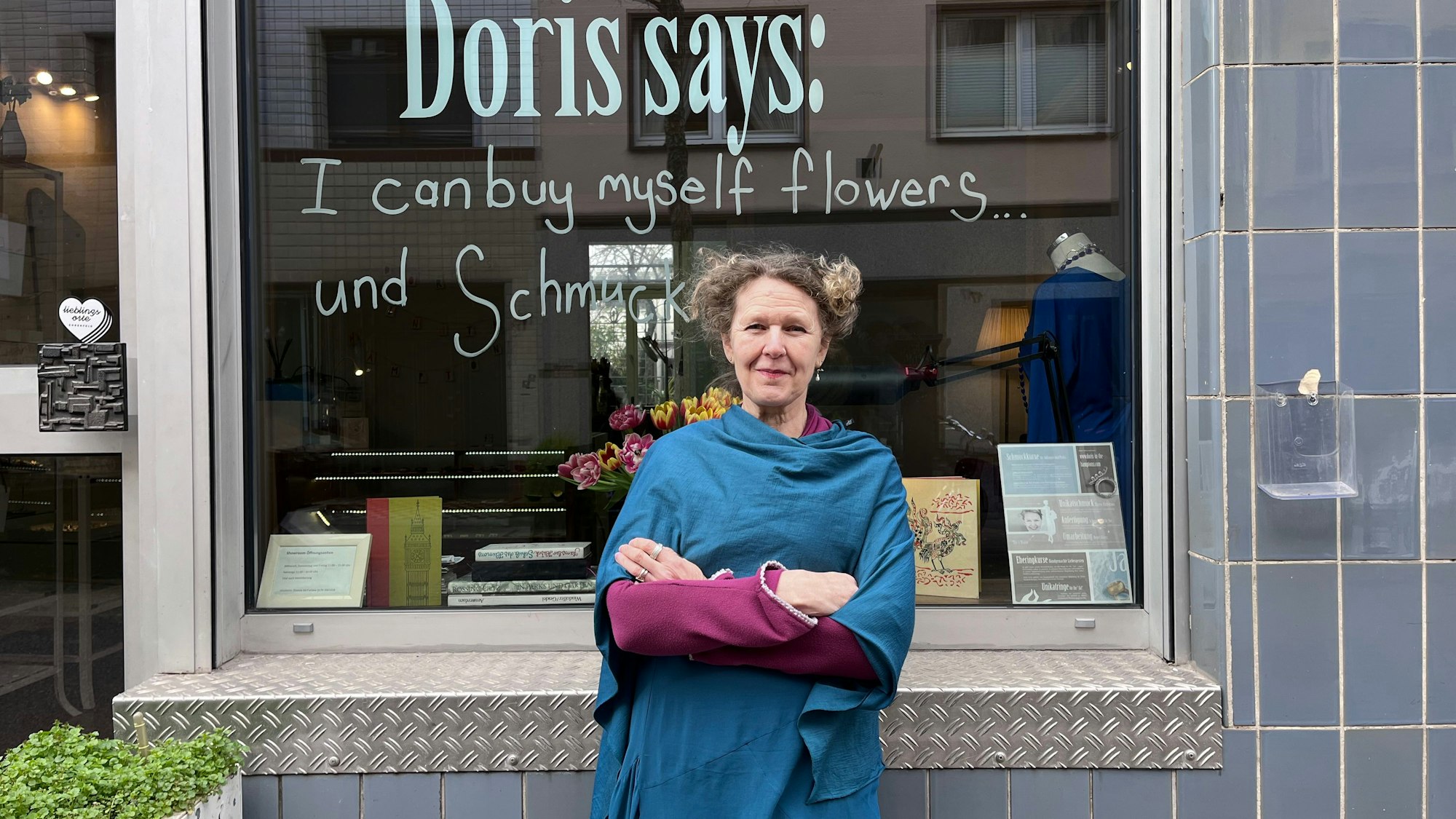 Eine Frau steht vor dem Schaufenster ihres Schmuckgeschäfts.