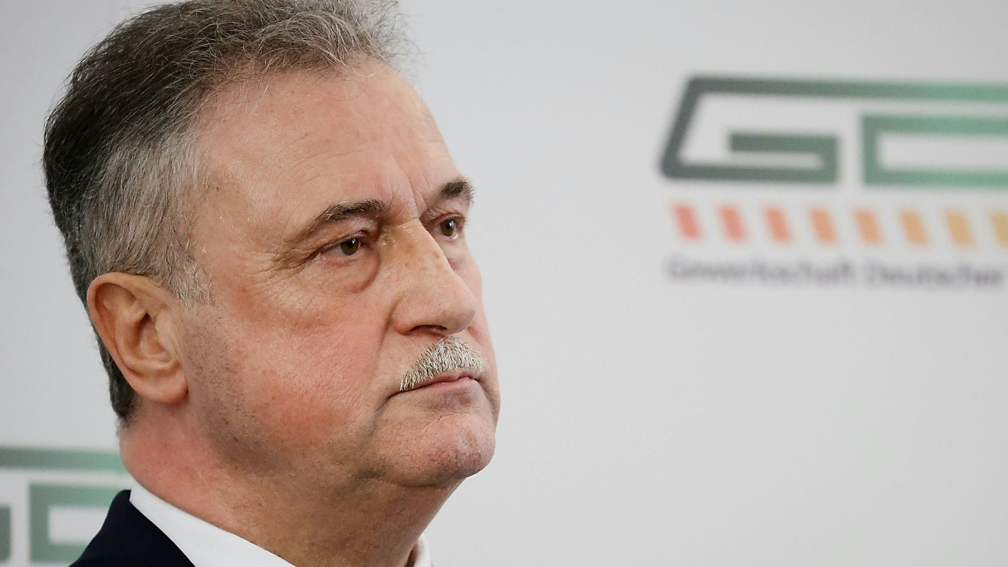 Claus Weselsky, Chef der Gewerkschaft Deutscher Lokomotivführer(GDL), sitzt bei einer Pressekonferenz vor einem Logo der GDL und beantwortet Fragen der anwesenden Journalistinnen und Journalisten.