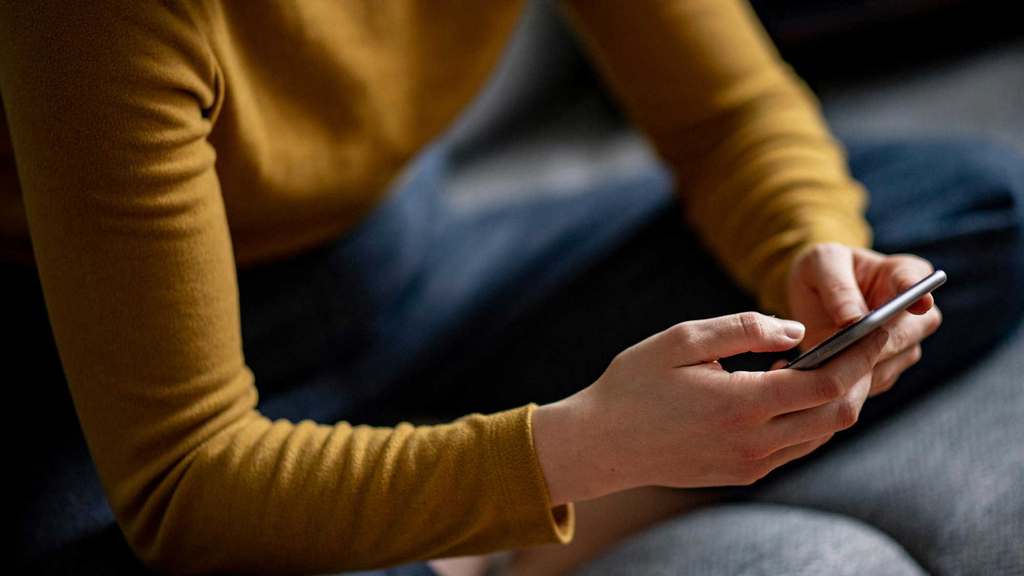 Eine Frau liest Nachrichten auf dem Smartphone