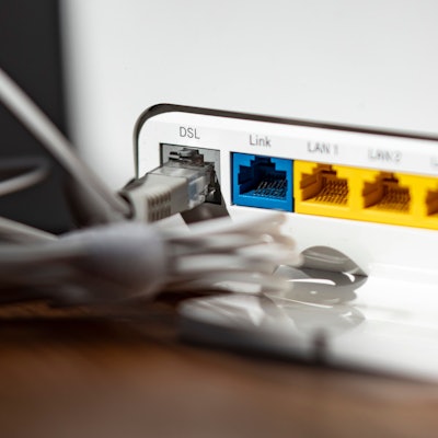Ein LAN-Kabel steckt im DSL-Steckplatz eines WLAN-Routers
