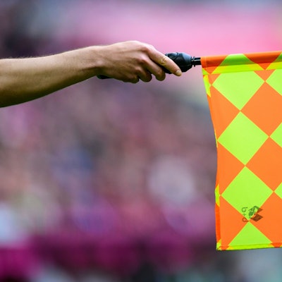 Der Linienrichter hält die Fahne und zeigt Abseits an.