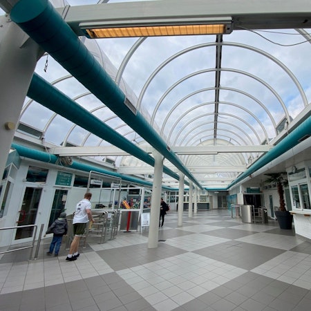 Zu sehe ist das gläserne Tonnendach eines Schwimmbads.